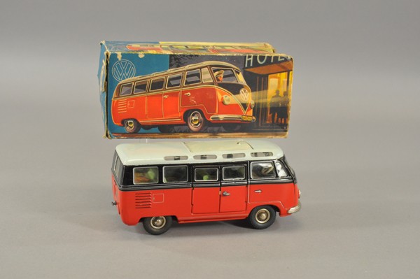 TIPPCO VOLKSWAGEN TRANSPORTER BUS WITH BOX: Germany, lithographed tin, done in red and black body, white roof, sliding sun roof, colorful tin litho seating, opening side door, electric lights. 9" l.