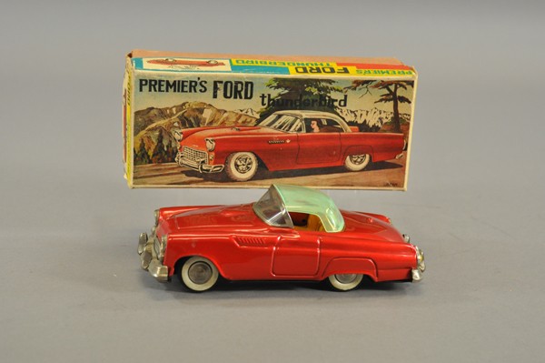 PREMIER'S FORD THUNDERBIRD WITH BOX: 1955 model, lithographed tin, bright red body, vaseline colored plastic roof, nickel grille, tin litho interior seating, friction powered. 8" l.