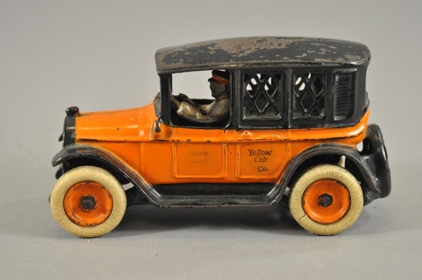 ARCADE YELLOW CAB BANK: c. 1927, cast iron, painted in yellow and black, mesh windows, coin slot at roof, trap on base, seated driver, door stenciled "Park" and phone number. 8" l.