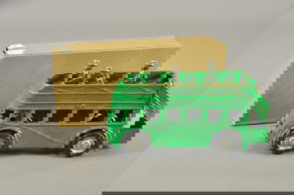 ARCADE BOXED DOUBLE DECKER BUS: c. 1940, cast iron painted in green overall, upper deck seating, rear stairway, nickel grille, rubber tires, includes three figures. 7 3/4" l.