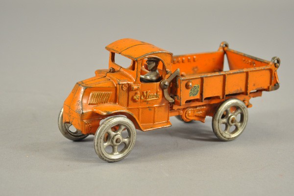 ARCADE MACK DUMP TRUCK: c. 1929, cast iron, painted in orange overall, rear bed tilts for unloading, decal on side, seated nickel driver and spoke wheels. 8 1/2" l.