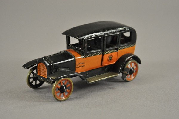 BING CHECKER CAB: Germany, c. 1920's, lithographed tin, orange and black body, Checker Cab logo in circle on side door, seated driver, spoke wheels, key wind operated. 7 3/4" l.