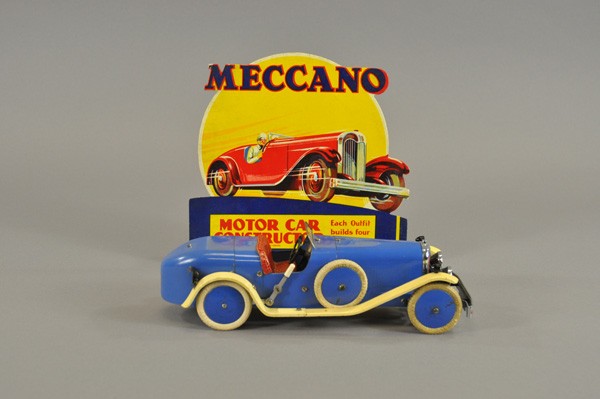MECCANO SPIDER: England, c. 1930's, pressed steel body, riveted and assembled fully, done in blue body, cream fenders, red seating, spare on side, clockwork driven, together with cardboard ad sign. 11 1/2" l.