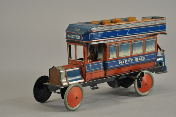 NIFTY BUS: Germany, c. 1930, lithographed tin, upper deck seats, seated driver, railed stairway, disc wheels, clockwork driven, destination reads, "Main Street," tin die-cut conductor stands on rear step. 9 3/4"