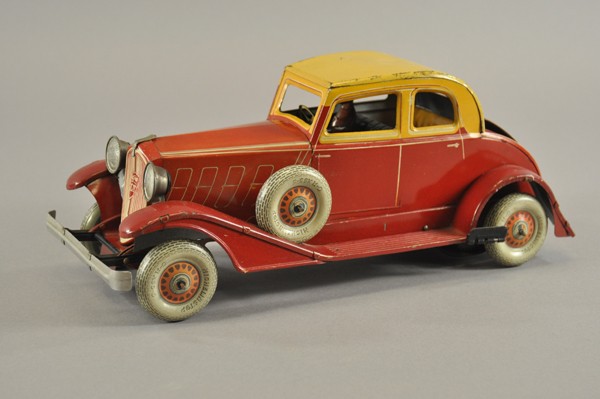 CHARLES ROSSIGNOL PEUGEOT COUPE: France, c. 1930's, lithographed tin, red body, yellow roof, seated tin driver, art deco grille in white and red, spare wheels mounted on both sides, clockwork mechanism, opening rumble seat. 14 1/4" l