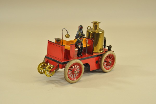 BING FIRE TRUCK: Germany, c. 1920, hand painted in red body, open bench seating, large vertical boiler gold finished, rear platform, hose reel on front, this is the clockwork version, also produced as steam powered, v