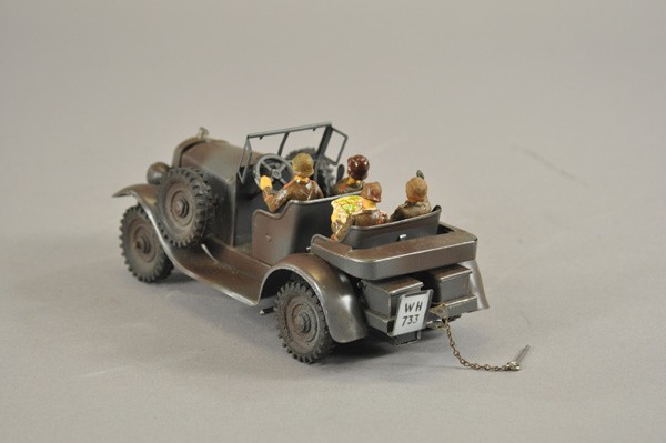 HAUSSER OFFICERS CAR: Germany, c. 1930's, tin plate open auto, contains four Lineol composition figures, rubber tires, spares on running boards, clockwork driven, done in deep camouflaged colors. 8 1/4" l.