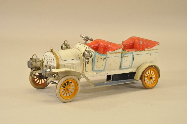 4612: BING FOUR SEAT OPEN TOURER: Germany, c. 1912, hand painted in white with embossed red seating, large scaled luxury toy, opening doors, rubber tires, spoke wheels, flaking to paint, has been stabilized, very visual piece, clockwo