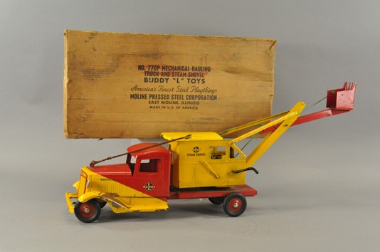 BUDDY "L" INTERNATIONAL TRUCK WITH SHOVEL: c. 1937, pressed steel with original box. Ref. Morou Sale. Duo-tone colors of red and yellow, flat service body features an enclosed housing with long shovel arm, hard rubber tires. 25 1/2" l.