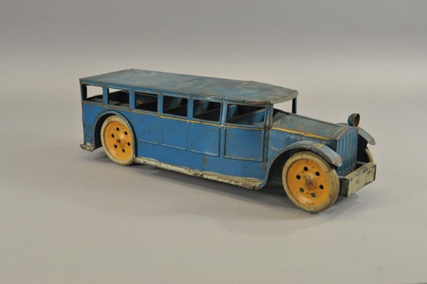 SCHIEBLE BUS: c. 1927, pressed steel, painted in blue overall, gold side stripe, spare mounted on rear, orange wheels, original white rubber tires, features Hill Climber friction motor. 20" l.