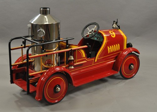 TOLEDO FIRE TRUCK PEDAL CAR: c. 1920's, pressed steel, painted in red body with yellow trim, features an impressive chrome plated boiler on service body, black railed side to rear platform, wood ladders supported on sides, nickel