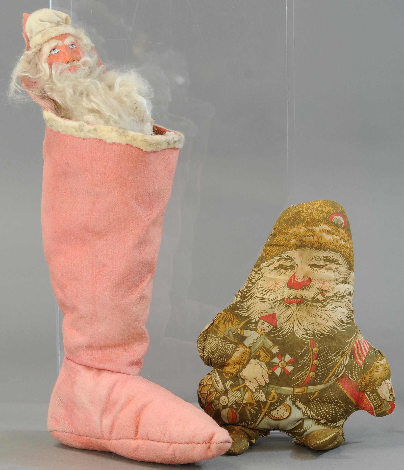 STUFFED COTTON SANTA & SANTA IN STOCKING: 2. STUFFED COTTON SANTA & SANTA IN STOCKING | Die-cast and stuffed cloth Santa, and a composition Santa w/rabbit fur beard, emerging from a stocking. | Santa doll 14"; stocking 20" | Some re-stitching