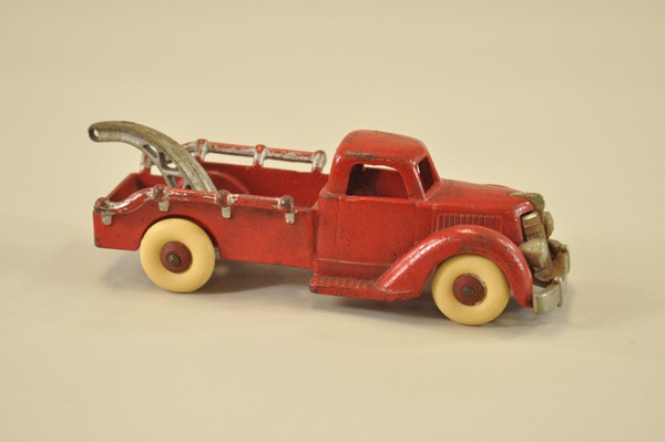 ARCADE TOW TRUCK: Cast iron, painted in red overall, nickel grille, silver boom, rubber tires, railed bed highlighted in silver. 8" l.