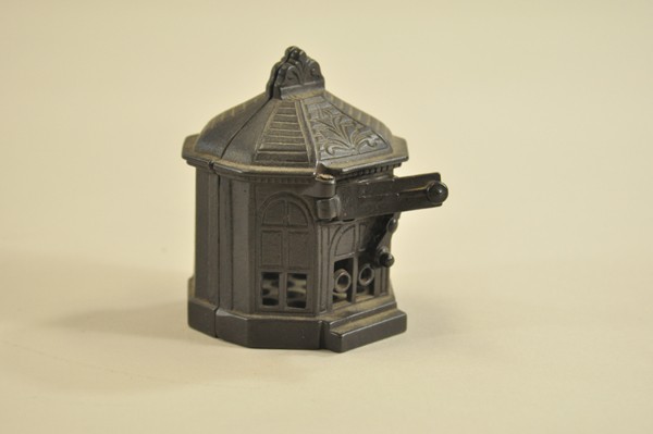 SNAPPIT BULDING STILL BANK: Judd Mfg. Co., circa 1885, pull the knob on the drawer to open and lock it in place; put a coin in it, push the lever, the drawer closes and deposits the coin into the bank. 4" h. x 3" w.