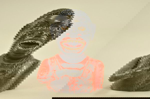 JOLLY "N" MECHANICAL BANK: John Harper Ltd., England, place a penny in hand and press the lever on the back, the arm moves up, the eyes roll back, the tongue moves in & the coin is deposited into the bank.