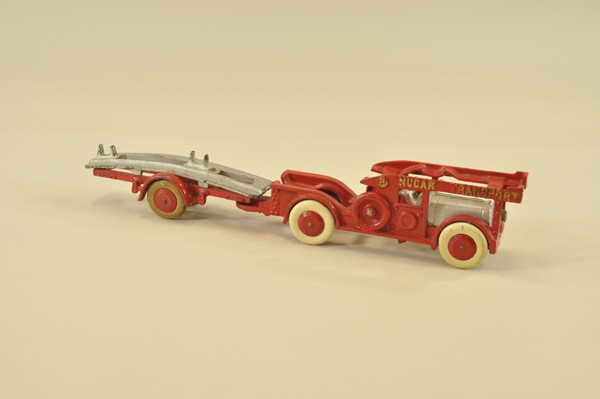 NU CAR TRANSPORT: Hubley, cast iron, painted red overall w/separate silver trailer bed, cab & driver, also painted silver, embossed lettering trimmed in gold. 16" l.