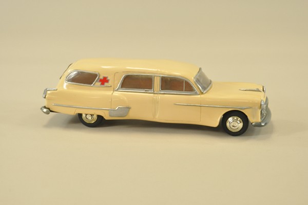 PACKARD "HENNY" AMBULANCE: AMC, plastic 1/20th scale, done in light cream color, red cross emblem, window inserts complete, clockwork driven, rubber tires. 12" l.