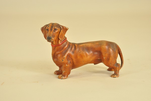 DACHSHUND DOORSTOP: Hubley, #326, full figure dachshund in reddish brown color with red color, excellent casting and shading. 6 1/4" x 9 1/2".