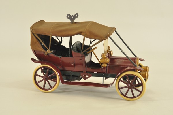 CONVERSE TOURING CAR: Pressed steel, painted in maroon overall, features canvas soft top, side lamps and head lamps, clockwork driven, unique winding access through roof, spoke wheels. 15 1/2" l.