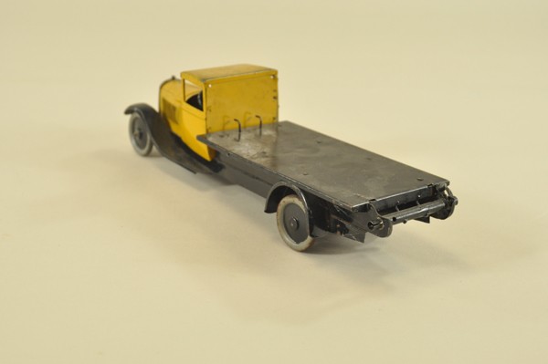CITROEN FLATBED LORRY: France, yellow tin body, black open flatbed, wind-up activated, roller bar on tail end for unloading, black fenders, plated grille. 12" l.