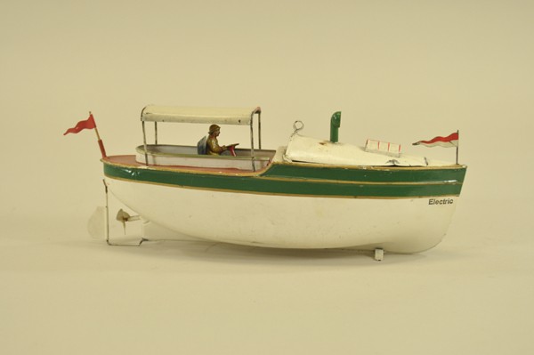 RIVERBOAT: Attributed to Carette, Germany, an unusual electric driven early tin boat, hand painted in white with green band, seated pilot, reads "ELECTRIC" on hull, canopy over seating, deck lifts for battery pl