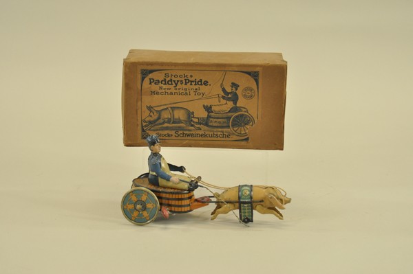 BOXED STOCK BUTCHER ON PIG DRAWN CART: Germany, lithographed tin, whimsical toy depicts butcher seated on barrel cart drawn by pig wearing litho tin blanket, clockwork driven. 8" l.