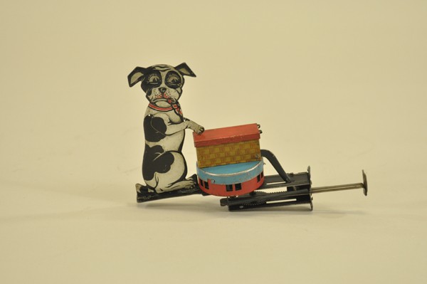 DOG WITH CAT IN PICNIC BASKET SIREN TOY: Germany, scarce example, lithographed tin, as plunger is depressed, siren sounds and cat lifts head from basket, works very well. 6" l.