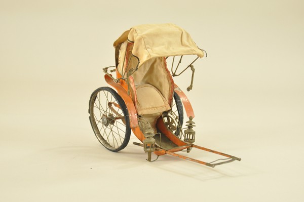 RICKSHAW TOY: Maker unknown, very early hand painted tin Rickshaw, upholstered seating ornate embossed beetle decor on sides, spoke wheels, rubber tires, well detailed, played with condition, but an incredible exam
