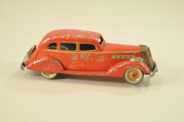 1936 PACKARD FOUR DOOR SEDAN: Kosuge, Japan, Pre-War example done in red tin lithography, nickel luggage rack, grille and lights, clockwork inoperative. 8 1/2" l.