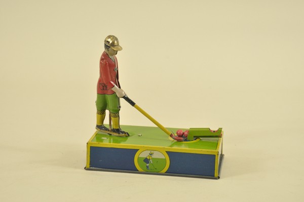 "JOCKO" THE GOLFER TOY: Lithographed tin, American tin toy depicts standing figure with golf driver in hand ready to drive balls when key wind is activated. 8 1/2" l.