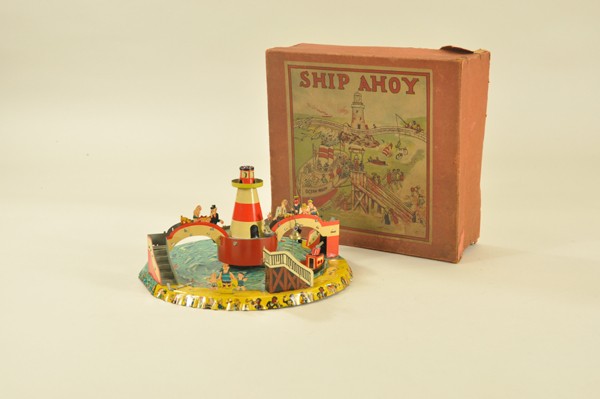 "SHIP AHOY" GAME TOY WITH BOX: Gama, Germany, lithographed tin, key wind operated, very interesting graphic images of children swimming on base, varied characters encircle base, features light house at center and stair bridges conn