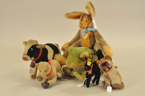 LOT OF FIVE STEIFF ANIMALS & BING CAT: Most circa 1950, lot consists of fancy jointed "Lulac" rabbit, cow, Siamese kitten, black velveteen "Halloween" cat and a large seated bullfrog. Also a key wind felt cat playing with metal ball (some
