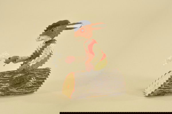 WONDERFUL NODDING RABBIT ON A LOG CANDY CONTAINER: Whimsical composition figure sits atop log candy container carrying bouquet of flowers in hand, strong nodding action, log opens on base for candy storage, .25 Wanamaker price tag on bottom. 4 3/4" h.