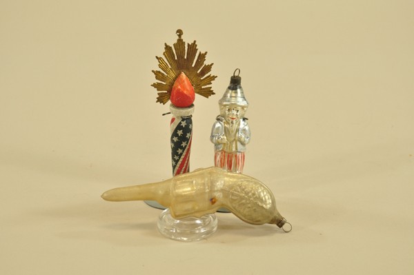 THREE ASSORTED GLASS ORNAMENTS: Nice assorted lot includes silvered pistol, silvered Uncle Sam with blue vest & striped pants and wooden torch done in painted pole shape with tin fire burst. 4"-5 1/2".