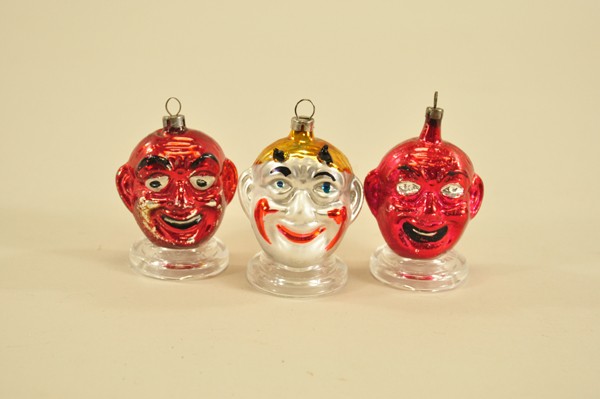 LOT OF THREE GLASS DEVIL HEAD ORNAMENTS: Germany, nice cross over collectible, each with sheepish grin on face, includes: devil head with annealed horns and two red devil heads without horns. 2 1/4"-2 1/2".