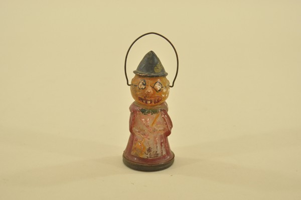 GLASS WITCH CANDY CONTAINER: Fabulous piece, opens at bottom (original tin base), pumpkin head witch wears hand painted glasses, molded with broom in hands and wide-toothed grin, wire bail handle. 4-3/4" t.