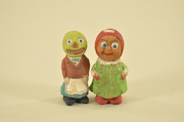 TWO CHALK HALLOWEEN CANDY CONTAINERS: Both early whimsical pieces, includes a melon head waiter and girl in cabbage leaf dress, heads remove for candy storage, colorful hand painted decoration. 3-1/2" t.
