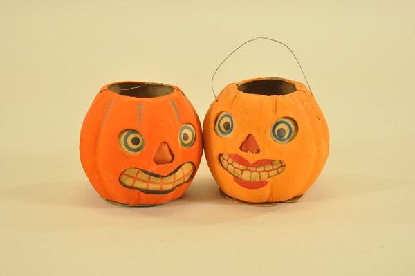TWO GERMAN JACK-O-LANTERNS: Papier mache, unusual lipstick make-up to one, whimsical paper face inserts, candle clips and wire handles present on both. 4-1/4" - 4-1/2" dia.