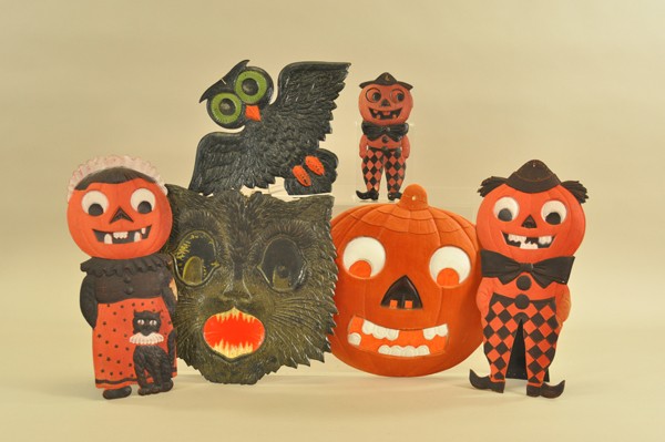 GROUP OF PRESSED HALLOWEEN DECORATIONS: German, die-cut pressed cardboard, includes a pumpkin head man and woman with easel back stands, large tissue backed jack-o-lantern, howling cat, an owl and smaller pumpkin head man. 8-1/2" - 15"