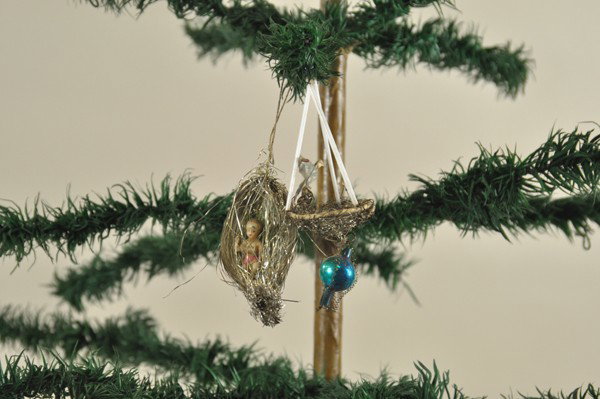 BIRD NEST AND CRADLE SEBNITZ ORNAMENTS: Interesting cradle is formed from long tinsel strands and gathered at ends; tinsel nest is supported with three long glass tubes, clever construction to both. 3" - 4-1/2" l.