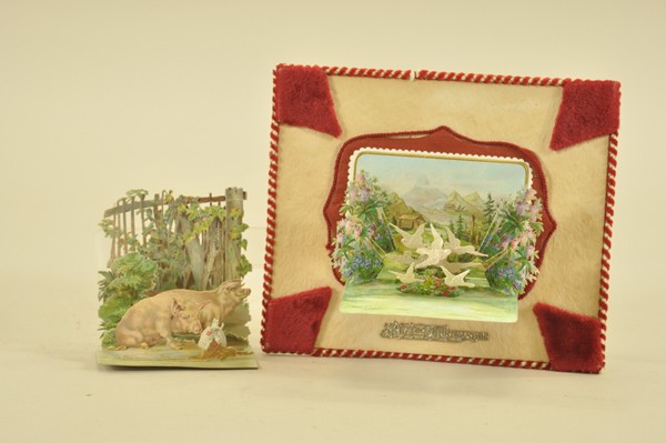 TWO RAPHAEL TUCK CHRISTMAS CARDS: Larger card opens to reveal countryside scene bursting with trees and flowers; smaller shows two pigs in a pen, both quite charming. 4" - 8-1/2" t.