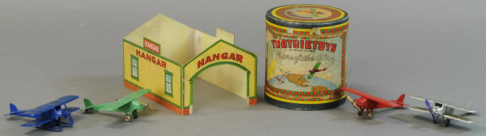 TOOTSIETOY ACES OF AIR AKANA W/ HANGAR: 429. TOOTSIETOY ACES OF AIR AKANA W/ HANGAR | Can has cardboard dividers. | Hangar, 6"x4.5", Can, 4.75" h. | Label of can is worn, hangar missing roof and seams are taped on inside, otherwise All Orig