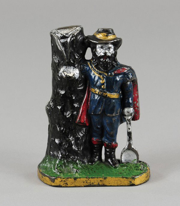 CAPTAIN KIDD STILL BANK: C. 1901, cast iron depiction of Captain Kidd with shovel in hand, stands by tree with coin slot at top of trunk, very colorfully painted. 5 5/8" h.