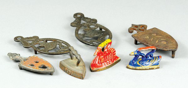 LOT OF SAD IRONS AND TRIVETS: Cast iron, includes two painted swan figural sad irons, four trivets and one advertising sad iron. 2 1/2" to 5" l.