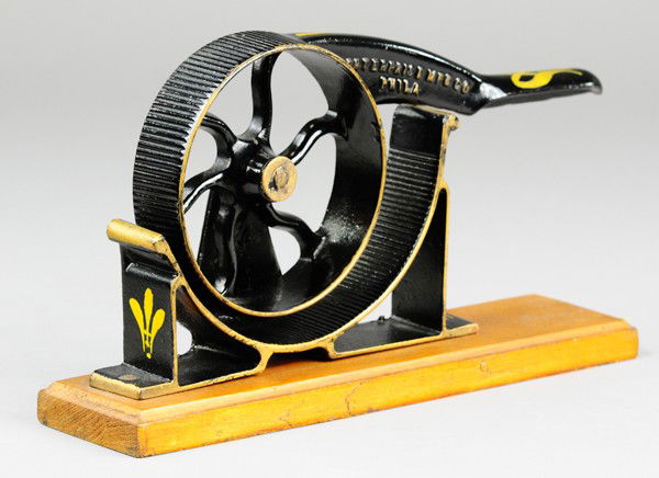 CAST IRON CORK PRESSER: Enterprise Mfg., Phila., painted in black and trimmed in gold, handle has décor detail, used to press corks for fitting into bottles. 11 1/2" l.