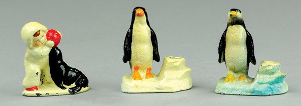 PENGUINS AND CHILD WITH SEAL PAPER WEIGHT: Cast iron, includes two Hubley penguin paper weight pencil holders together with an amusing child in snow suit playing ball with seal. 2" to 2 3/8" h.