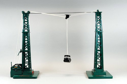 BUDDY 'L' AERIAL TOWER TRAMWAY: C. 1928, two dark green latticework towers with power tower having gear box for moving clam shell bucket between both towers.