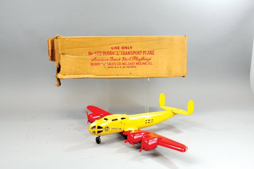 BUDDY 'L' TRANSPORT PLANE WITH BOX: Pressed steel, done in red wings, yellow fuselage, features four propellers, decal on sides, cockpit area has window openings, wooden wheels for rolling. 13" l.