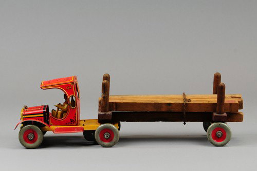 STRAUSS LUMBER KING TRUCK: Lithographed tin, open 'C' cab style with driver, long open bed log wagon, key wind operated, disc wheels. 18" l.