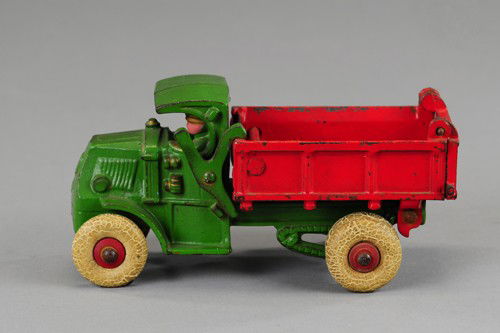 HUBLEY MACK DUMP TRUCK: Cast iron, 'C' Mack cab with cast driver at window, painted in green, dump body with opening tailgate done in red, white rubber tires. 7" l.